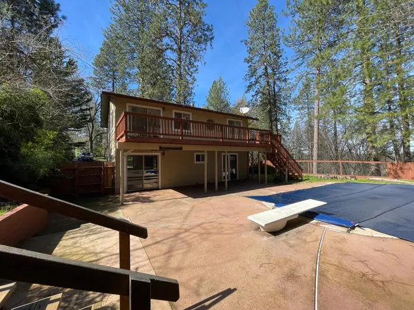 a view of house with yard and trees in the background