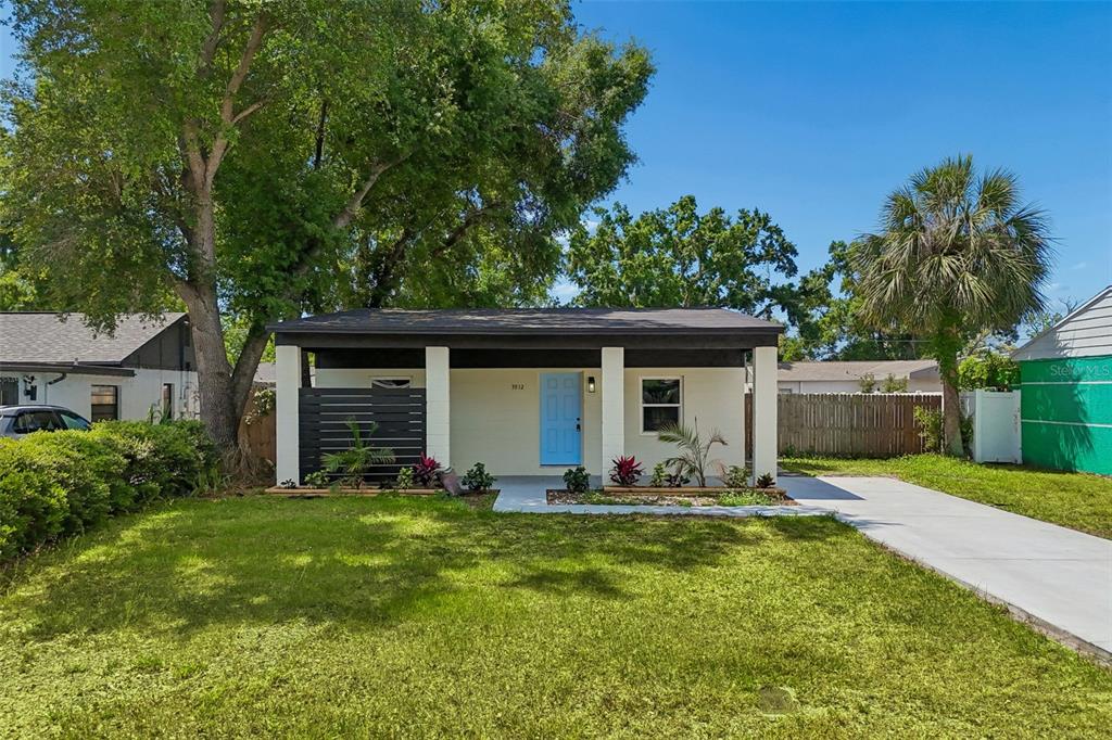 3912 West Pine Street Tampa, FL 33607 - Photo 1 of 60 a front view of house with yard and trees in the background