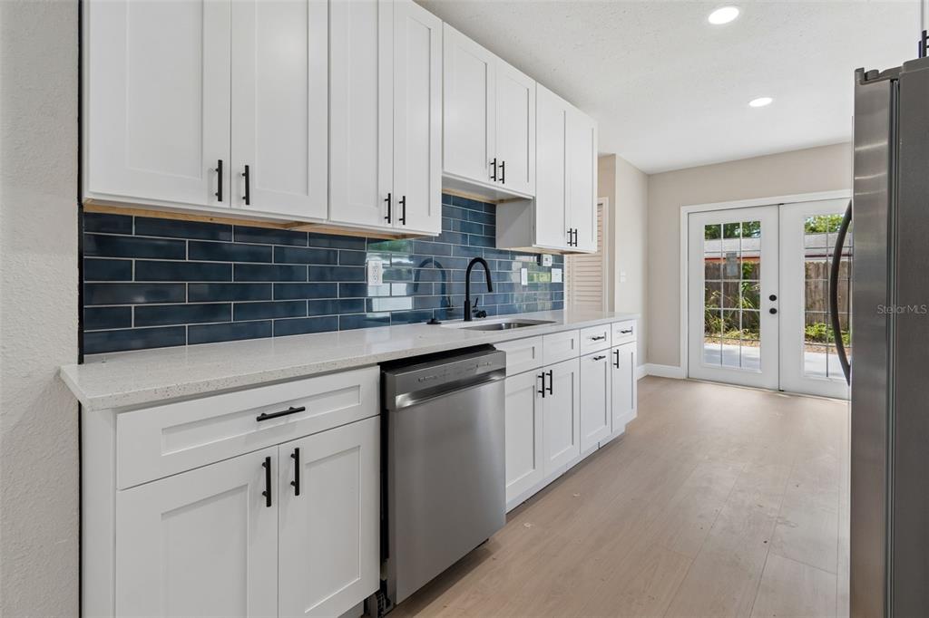 3912 West Pine Street Tampa, FL 33607 - Photo 15 of 60 a kitchen with granite countertop white cabinets and white appliances