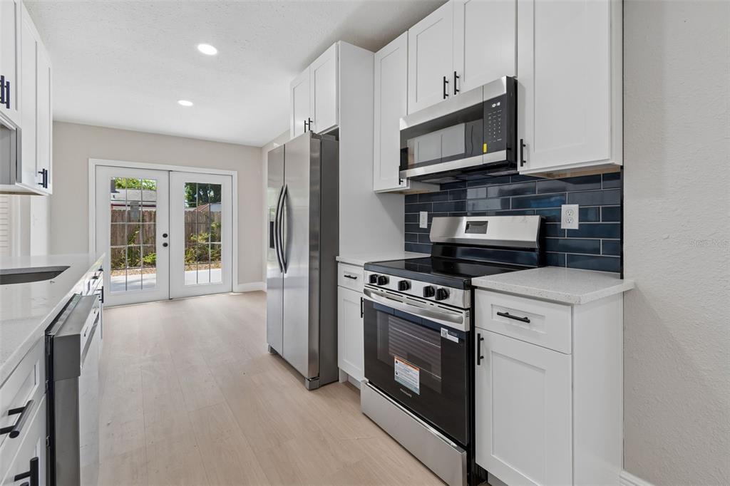 3912 West Pine Street Tampa, FL 33607 - Photo 16 of 60 a kitchen with stainless steel appliances granite countertop a stove a microwave and a refrigerator