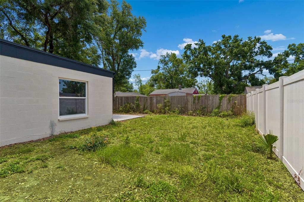 3912 West Pine Street Tampa, FL 33607 - Photo 40 of 60 a view of a backyard with large trees and wooden fence