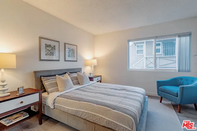 a bedroom with bed couch and window