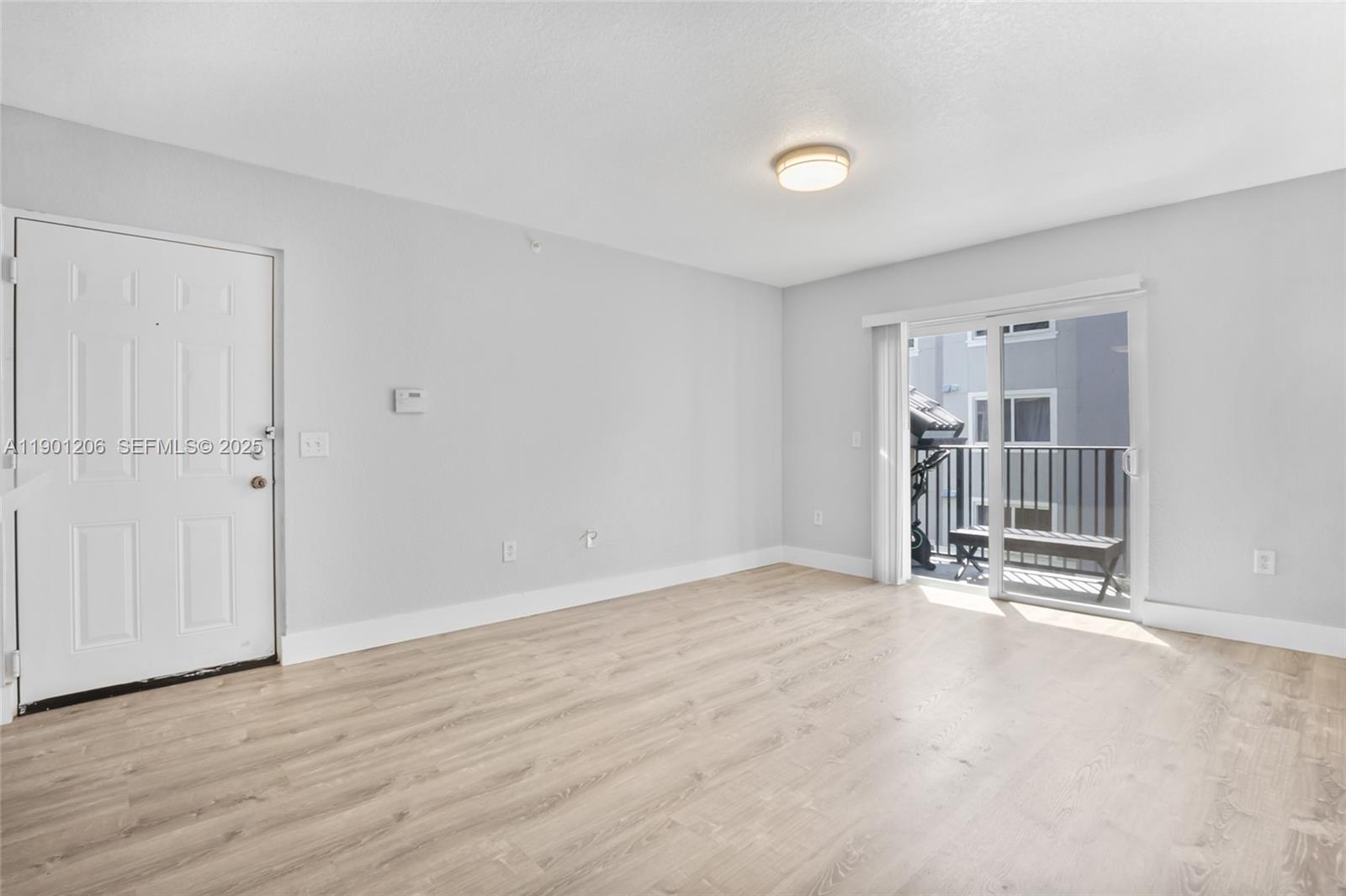 15410 Southwest 284th Street, Unit 8208 Homestead, FL 33033 - Photo 6 of 20 an empty room with wooden floor and windows