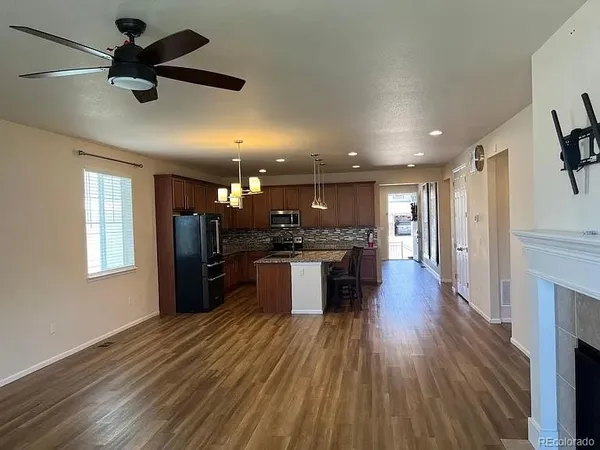 a view of kitchen with refrigerator microwave and stove with wooden floor