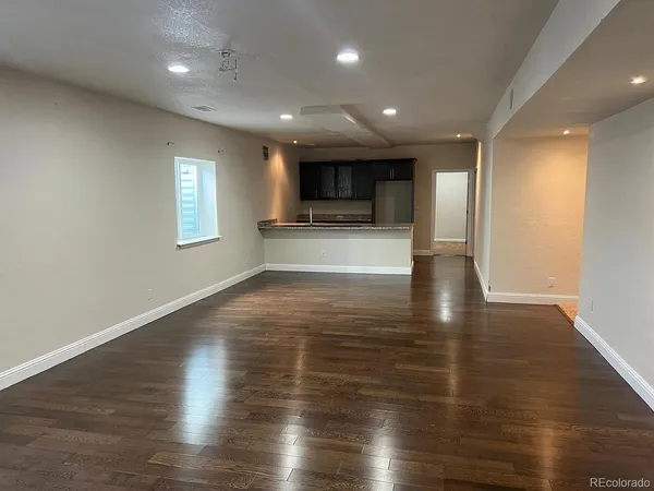 a view of empty room with wooden floor and windows