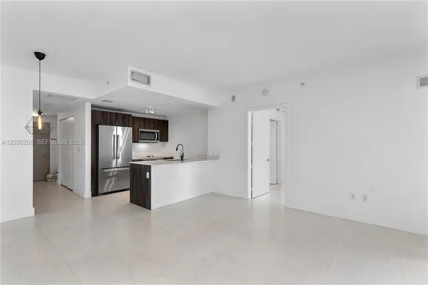 a large kitchen with a refrigerator and a stove top oven