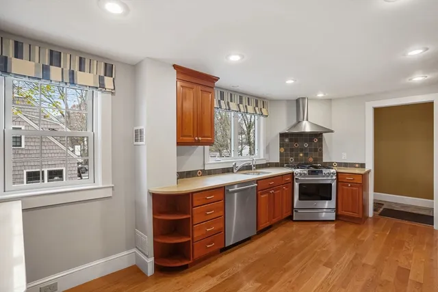 a kitchen with stainless steel appliances granite countertop a stove a sink and a refrigerator