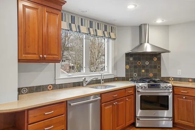 a kitchen with stainless steel appliances granite countertop a sink stove and cabinets