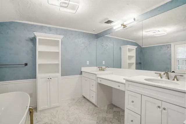 a bathroom with a double vanity sink a mirror and a bathtub