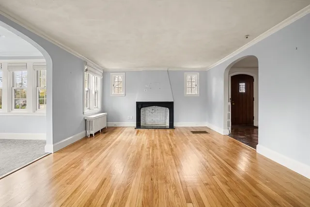 a view of empty room with wooden floor and fireplace