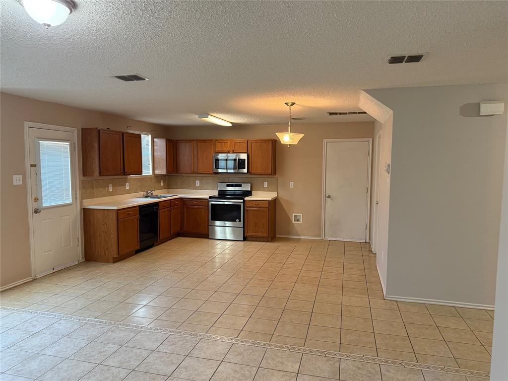 2011 Cap Rock Lane Grand Prairie, TX 75052 - Photo 4 of 9 a large kitchen with cabinets and stainless steel appliances