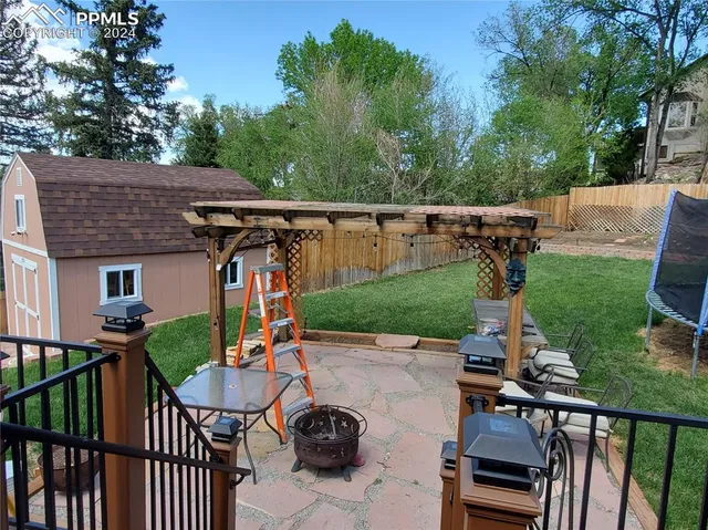 a view of a patio with chairs and potted plants
