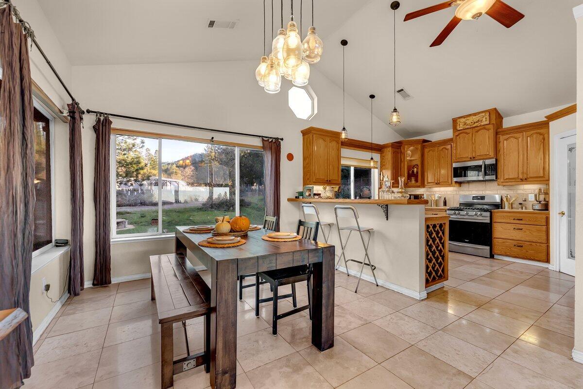 12757 Fern Road Whitmore, CA 96096 - Photo 15 of 62 a open dining room with stainless steel appliances kitchen island granite countertop furniture and a large window