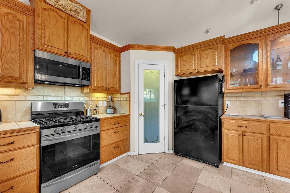 12757 Fern Road Whitmore, CA 96096 - Photo 19 of 62 a kitchen with stainless steel appliances granite countertop a stove top oven a refrigerator and cabinets