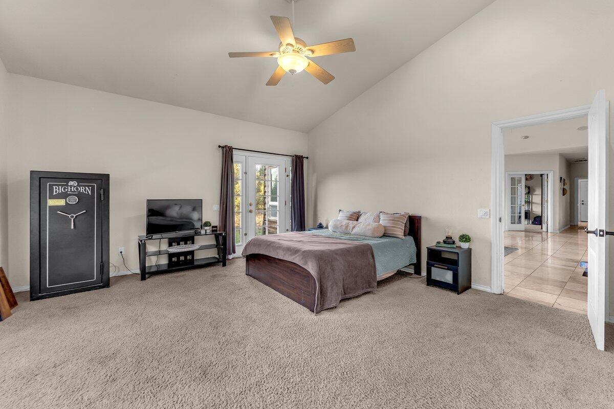 12757 Fern Road Whitmore, CA 96096 - Photo 21 of 62 a spacious bedroom with a bed and a chandelier