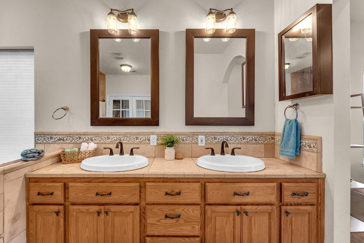 12757 Fern Road Whitmore, CA 96096 - Photo 23 of 62 a bathroom with double vanity sinks and a mirror