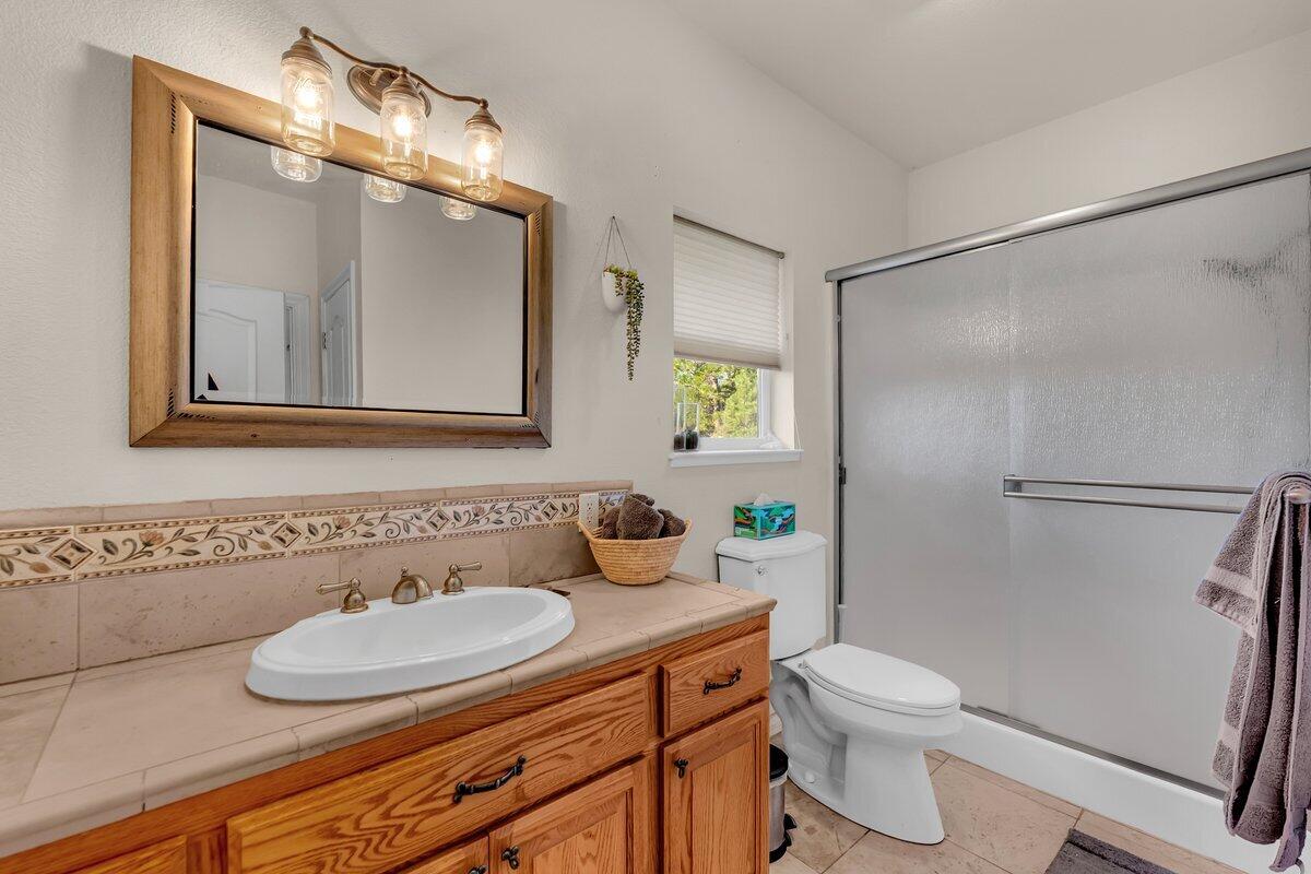 12757 Fern Road Whitmore, CA 96096 - Photo 29 of 62 a bathroom with a granite countertop sink mirror vanity and toilet