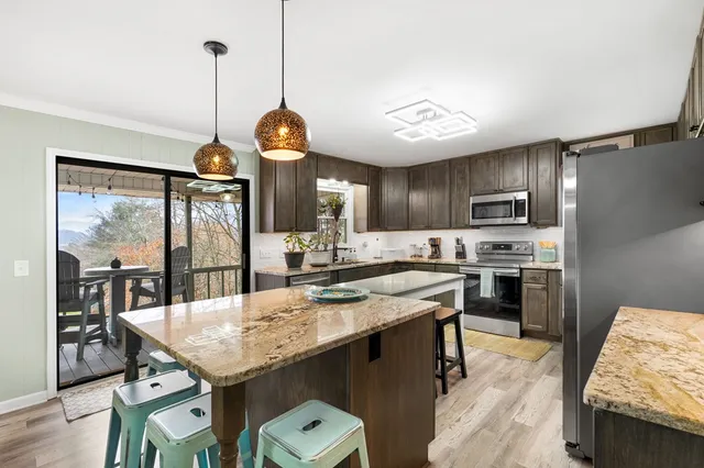 a kitchen with sink a stove and chairs