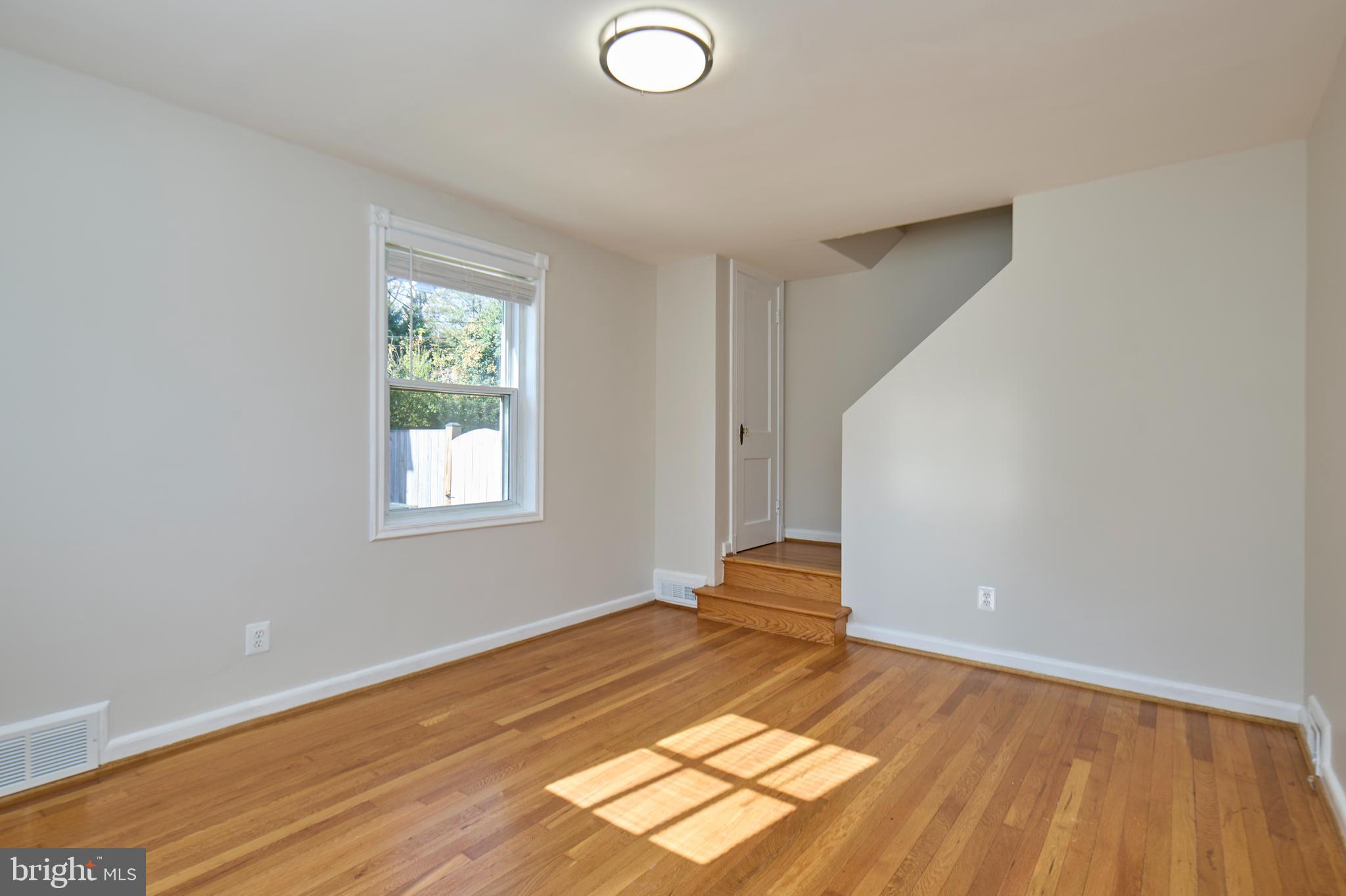 3727 2nd Street South Arlington, VA 22204 - Photo 3 of 30 an empty room with wooden floor and windows