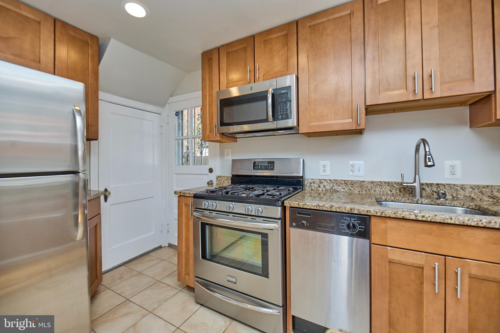 3727 2nd Street South Arlington, VA 22204 - Photo 10 of 30 a kitchen with granite countertop wooden cabinets stainless steel appliances and a counter space