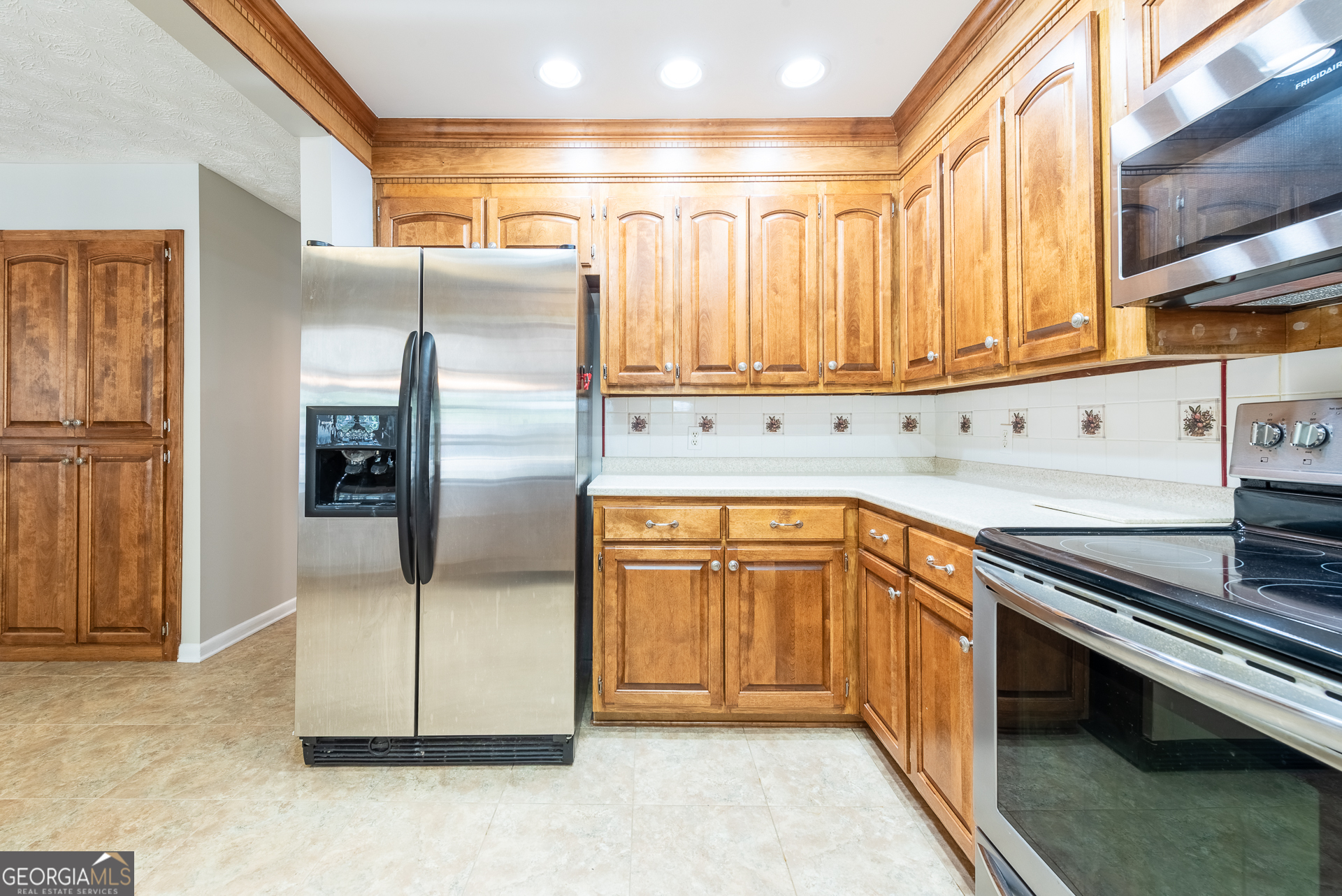 4582 St Johns Church Road Blackshear, GA 31516 - Photo 39 of 76 a kitchen with stainless steel appliances granite countertop a refrigerator a sink and white cabinets