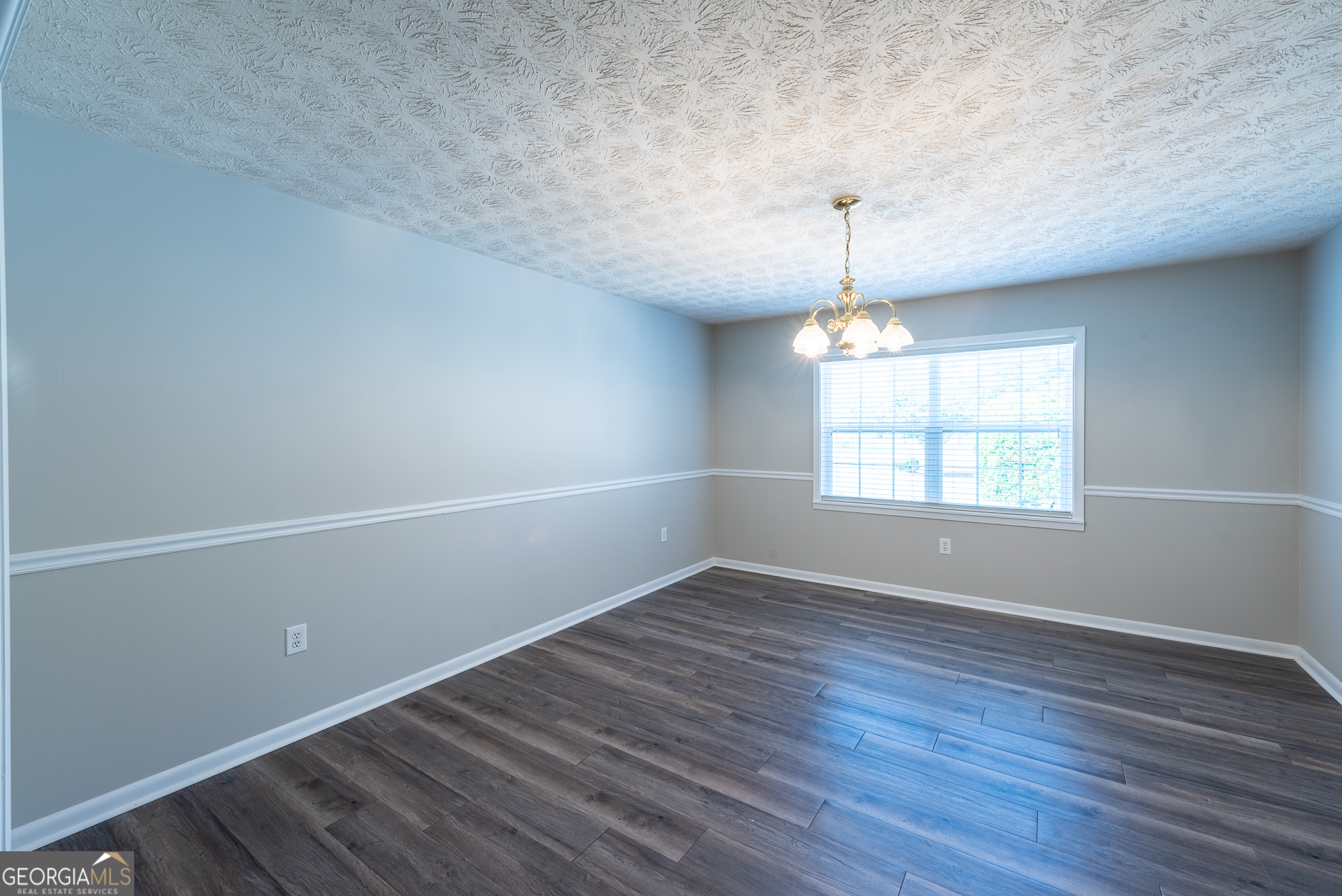 4582 St Johns Church Road Blackshear, GA 31516 - Photo 45 of 76 an empty room with wooden floor chandelier and windows