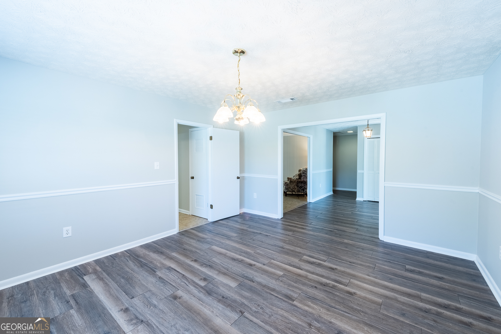 4582 St Johns Church Road Blackshear, GA 31516 - Photo 49 of 76 a view of a room with wooden floor and a chandelier