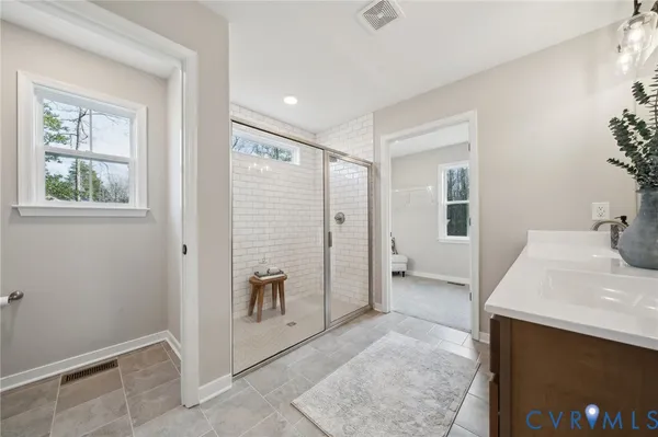 a bathroom with a double vanity sink a mirror and a shower