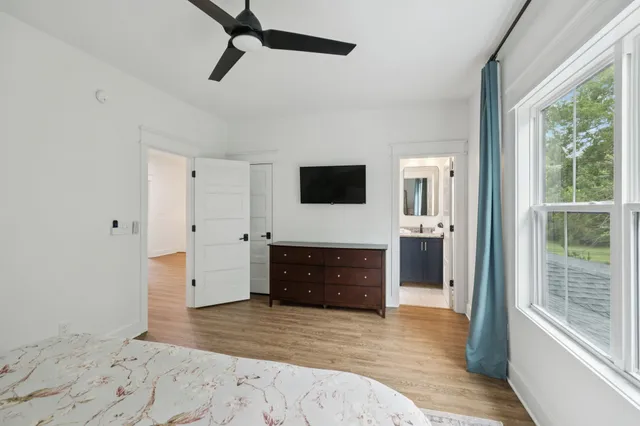 a view of a backyard with table and chairs potted plants and large tree