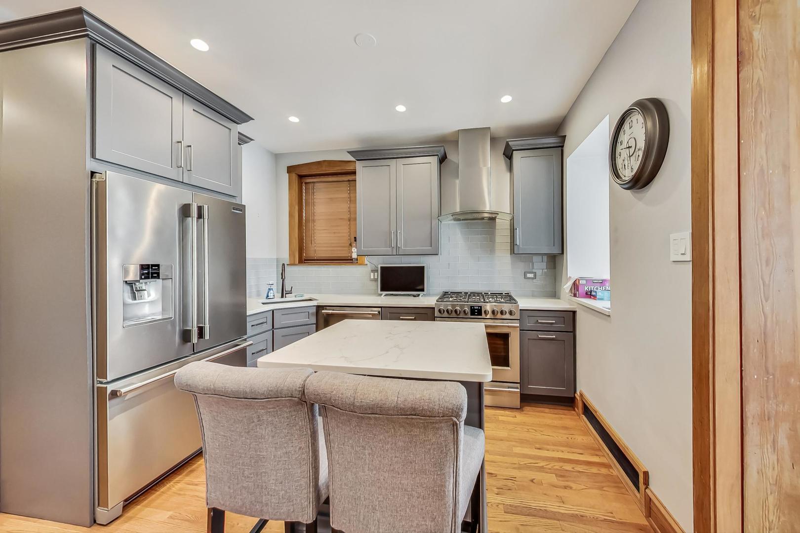 3929 North Drake Avenue Chicago, IL 60618 - Photo 16 of 60 a kitchen with stainless steel appliances granite countertop a refrigerator and a stove