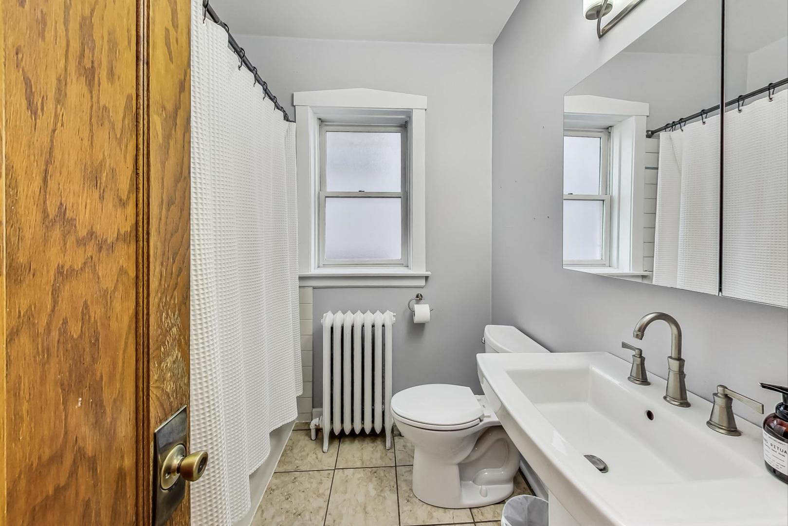 3929 North Drake Avenue Chicago, IL 60618 - Photo 24 of 60 a white toilet sitting next to a bathroom sink