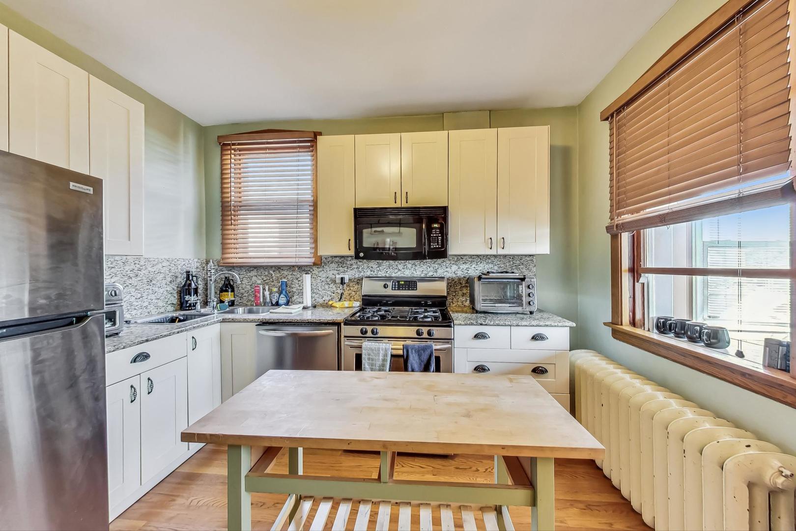 3929 North Drake Avenue Chicago, IL 60618 - Photo 34 of 60 a kitchen with stainless steel appliances granite countertop a stove top oven a sink dishwasher and a refrigerator with wooden floor
