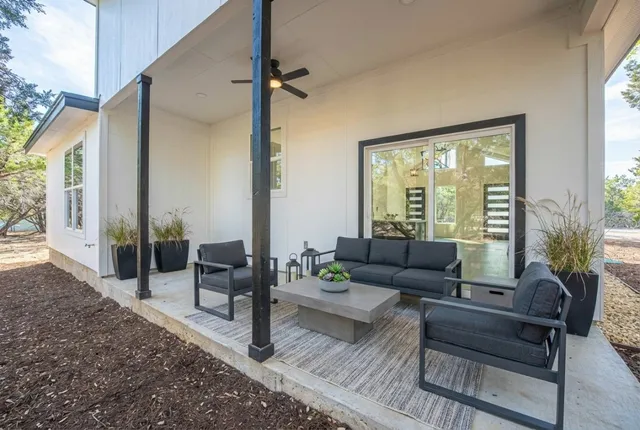 an empty room with wooden floor ceiling fan and windows