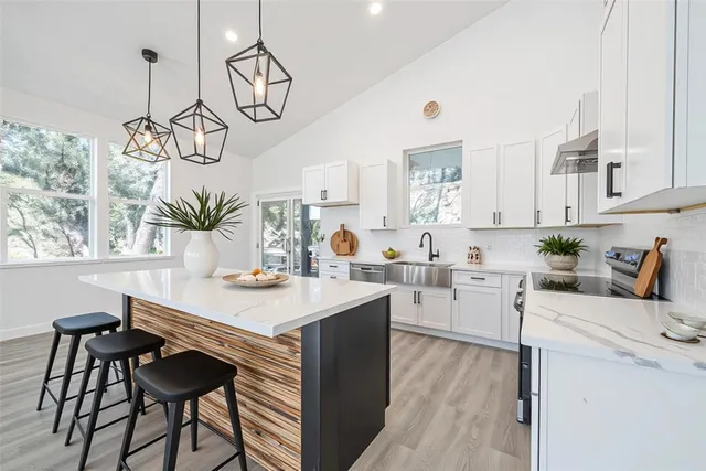 a kitchen with a table chairs and white cabinets