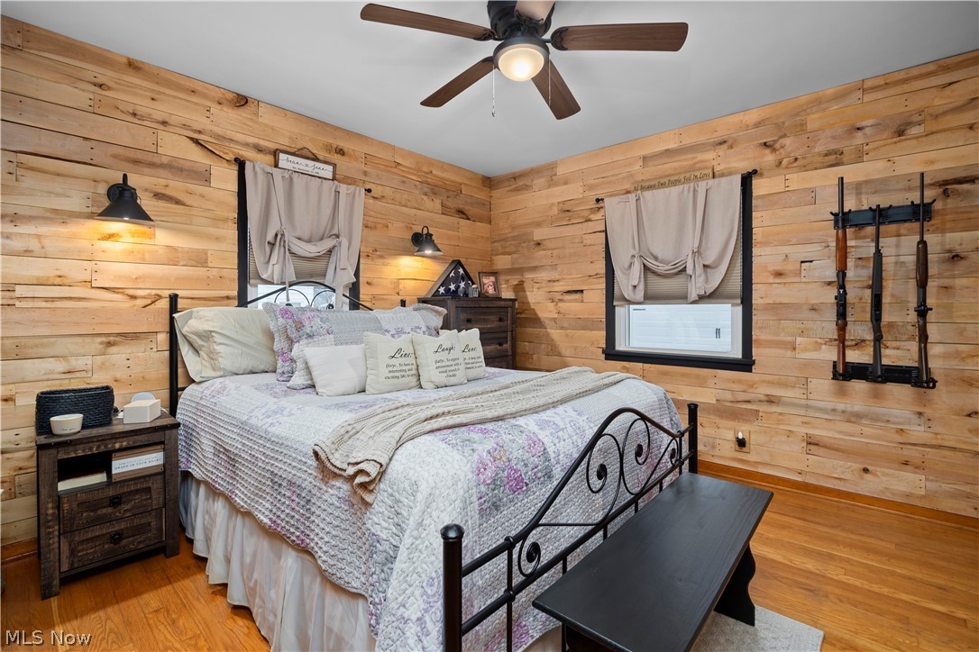 965 Gulf Road Elyria, OH 44035 - Photo 15 of 37 Master Bedroom featuring wooden walls, a ceiling fan, and light hardwood flooring