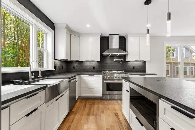 a kitchen with stainless steel appliances granite countertop a stove sink and cabinets