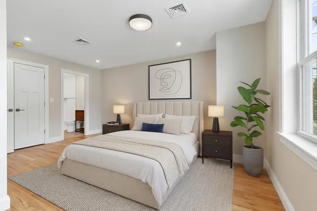 a bedroom with bed and a potted plant