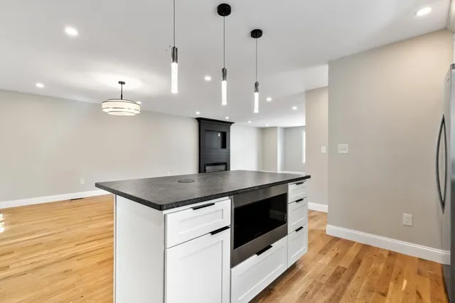 a kitchen with a stove and a wooden floor