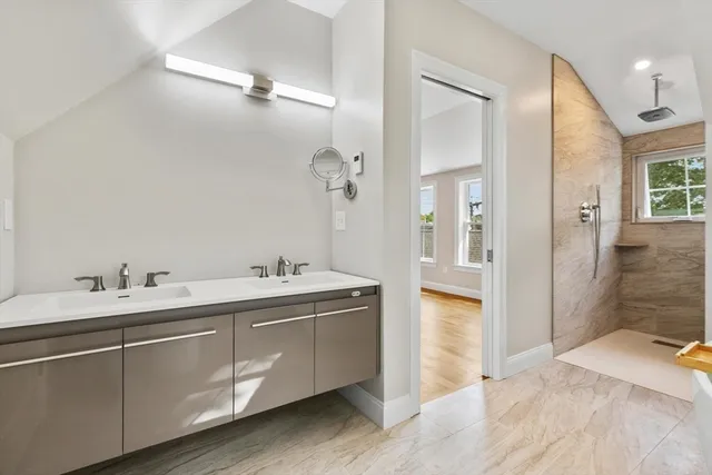 a spacious bathroom with a double vanity sink mirror and shower