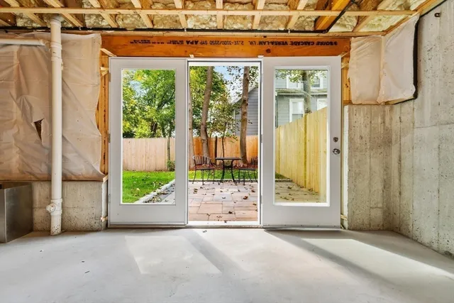 a view of a white house with large windows and a small yard