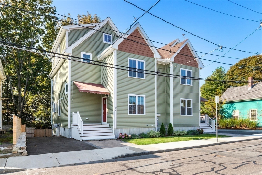 17 Emerson Street Stoneham, MA 02180 - Photo 40 of 41 a view of a white house with large windows and a small yard