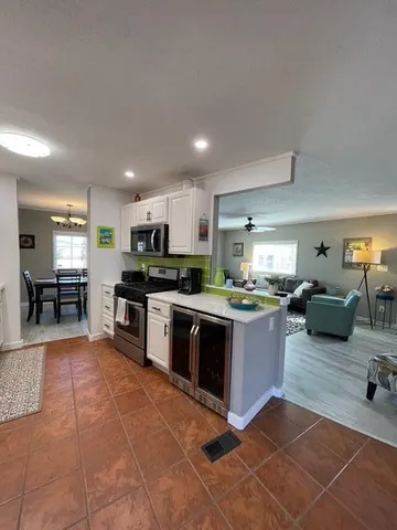 a kitchen with stainless steel appliances granite countertop a stove top oven a sink counter space and living room view