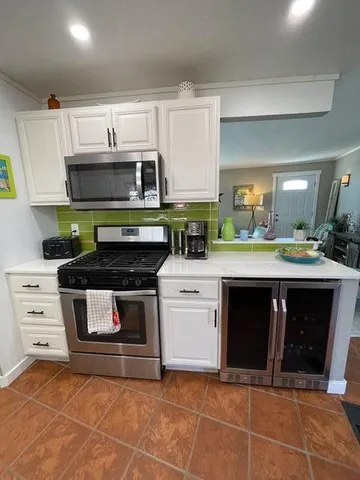 a kitchen with stainless steel appliances granite countertop a stove a sink and a microwave
