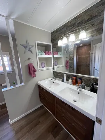 a bathroom with a sink toilet a mirror and window