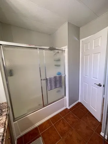 a room with a dining table chairs and view of kitchen