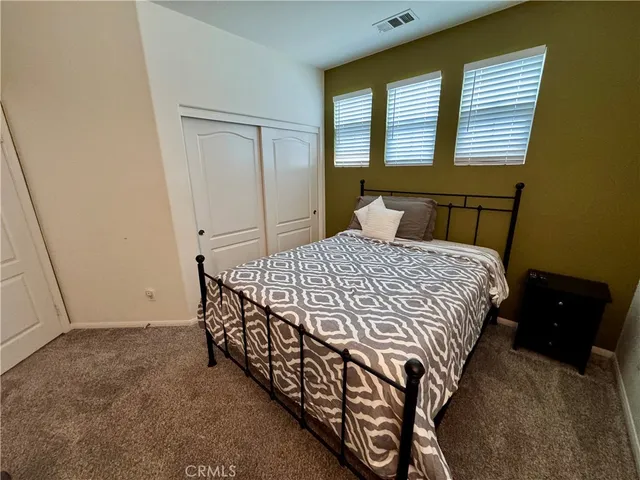 a bedroom with a bed chair and a window