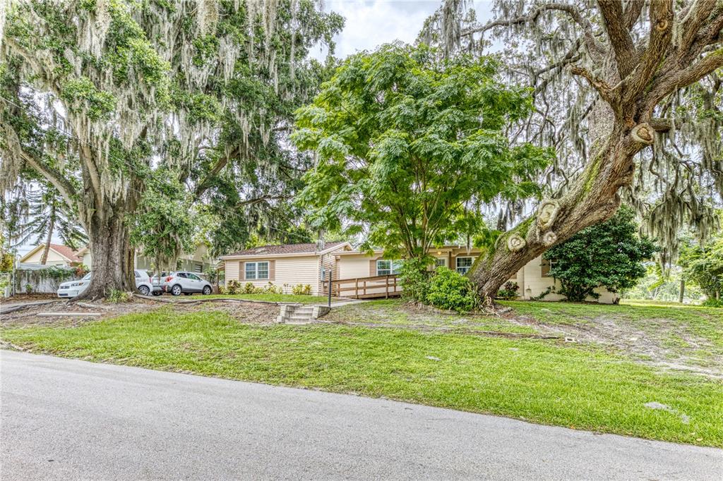 a front view of a house with a yard and trees