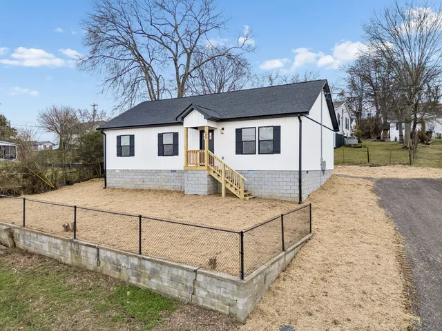 a white house that has tree in front of it