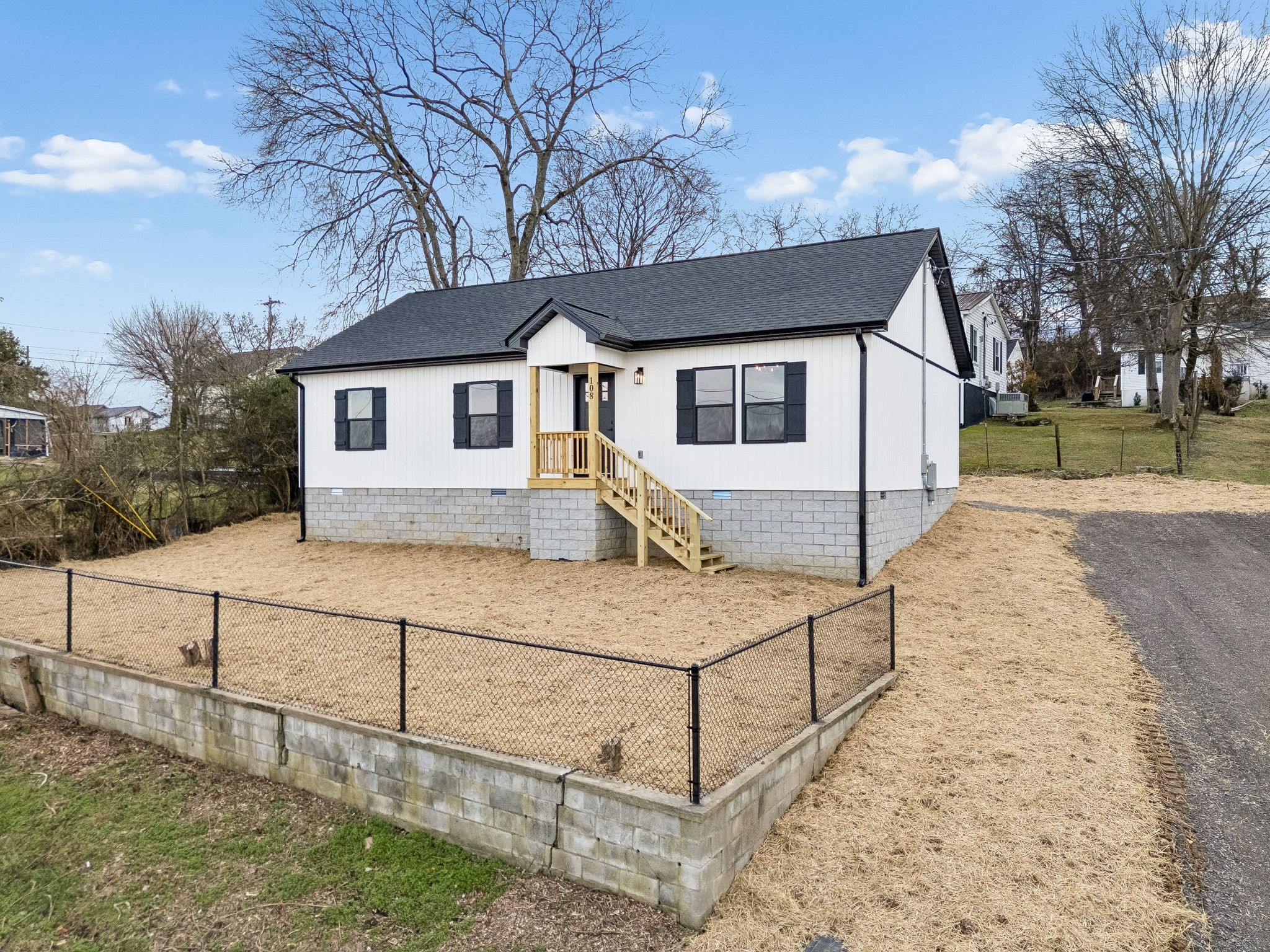 a white house that has tree in front of it