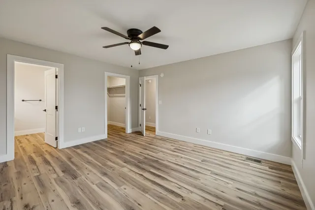 a view of empty room with wooden floor